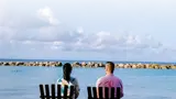 a couple looking outwards towards a beach