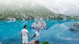 Couple in front of a body of water and mountain